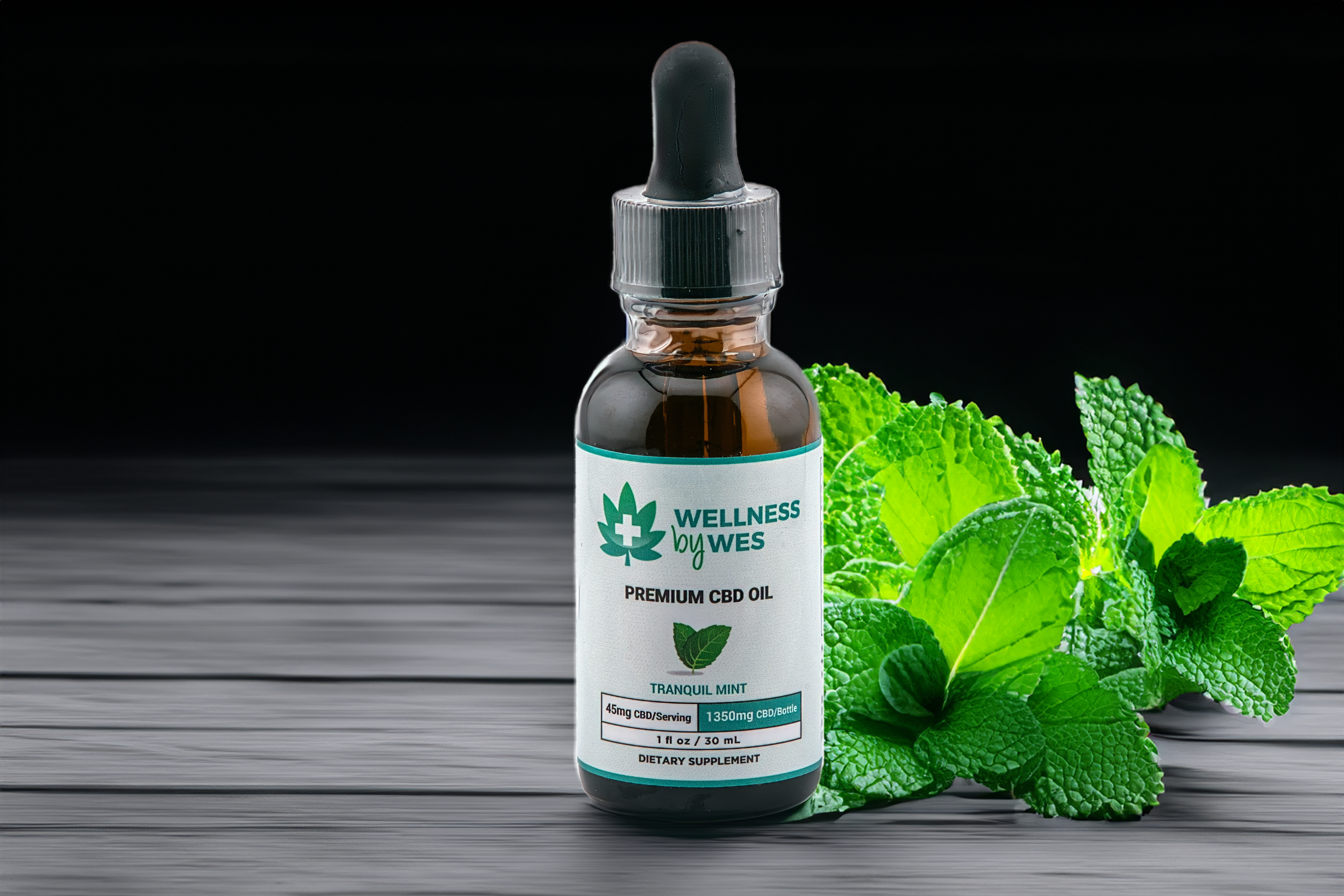 Wellness by Wes Tranquil Mint CBD Oil Tincture, with vibrant green mint leaves in the background, suggesting a refreshing flavor and natural ingredients.