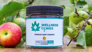 Jar of Wellness by Wes Premium Hemp Gummies with Serene Orchards flavor, 300mg total, next to a fresh apple in a natural garden setting. Serene Orchard 300mg CBD Gummies - Wellness by Wes